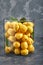 Fresh, yellow apricots in a glass vase. Fruits on a gray background. Copy space, abstraction, advertising photo.