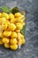 Fresh, yellow apricots in a glass vase. Fruits on a gray background top view. Copy space, abstraction, photo for grocery