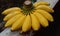 Fresh yellow bananas are placed on the cement bench. Selective focus.