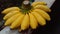 Fresh yellow bananas are placed on the cement bench. Selective focus.