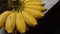 Fresh yellow bananas are placed on the cement bench. Selective focus.