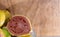 Fresh yellow guavas and broken in glass bowl on neutral background