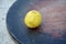 The fresh yellow ripe lemon on the maroon wooden background