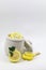 Fresh yellow sliced lemon scrub and crystal sugar rock candy mint and leaf in a white cup jar isolated white background