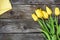 Fresh yellow tulip flowers with towel on ancient vintage wooden table.