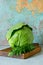 Fresh young cabbage on a wooden kitchen board for shredding on a blue background. Vegetables for cutting salad. Vegan food,