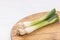 Fresh young onions above wooden cutting board