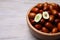 Fresh Ziziphus jujuba fruits in bowl on wooden table, closeup. Space for text