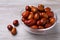 Fresh Ziziphus jujuba fruits with glass bowl on wooden table, closeup