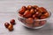 Fresh Ziziphus jujuba fruits with glass bowl on wooden table, closeup