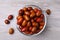 Fresh Ziziphus jujuba fruits with glass bowl on wooden table, flat lay