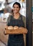 The fresher the better. a young woman holding a selection of freshly baked breads in her bakery.