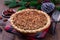 Freshly baked American apple cranberry pie, topped with crumbled dough and pecan, in baking dish