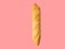 Freshly baked artisan whole baguette with golden crusty floury texture on pink background