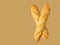 Freshly baked artisan whole baguettes with golden crusty floury texture on light brown background