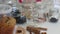 Freshly baked banana bread is on the table. The ingredients for decorating it are placed around. The woman is getting ready for