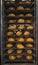 Freshly baked bread loaves on tray track trolley. Metal shelves with bread buns