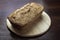 Freshly baked buckwheat bread. A loaf of bread lies on a round kitchen board on a brown wooden table. Gluten-free