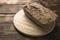 Freshly baked buckwheat bread. A loaf of bread lies on a round kitchen board on a brown wooden table. Gluten-free