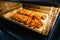 Freshly baked chicken fillet on a baking sheet in an electric oven. Cooking chicken nuggets. Series