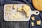 Freshly baked corn bread on a wooden white board with corn and flour on a dark background with a napkin. Traditional pastries in