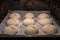 freshly baked crispy buns in the oven on the tray, process of cooking mini small bread