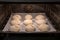 freshly baked crispy buns in the oven on the tray, process of cooking mini small bread