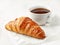 Freshly baked croissant and coffee cup
