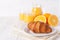 Freshly baked croissant, orange juice, fresh fruits, jam on white wooden background. French breakfast. Fresh pastries