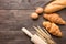 Freshly baked croissants, baguette and eggs on wooden background