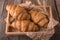 Freshly baked croissants on wooden boards, with wheat eart.