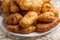 Freshly baked delicious pies with a brown crispy crust lie on a white ceramic plate.