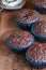 Freshly baked double chocolate muffins on a wooden background wi