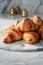 Freshly baked flaky golden croissants on marble surface, generative AI