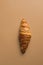 Freshly baked French buttery flaky croissant on brown tabletop background. Breakfast energy concept