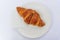 Freshly baked French croissant on a plate at breakfast at a bakery cafe in Nice, France, flat lay top down view