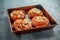 Freshly baked French raisin buns. Pains aux raisins on a vintage baking tray