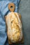 Freshly Baked Hand Crafted Rustic Bread Loaf on Cutting Board Dark Stone Background. Authentic Rustic Style. Lifestyle.