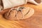 Freshly baked homemade bread with bran on a wooden background and burlap and with a willow sprig. Foodphoto