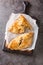 Freshly baked homemade Cornish pasties closeup on the wooden board. Vertical top view