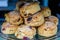 Freshly baked homemade English scones with dried fruits, displayed as a pyramid, available for sale at a cafÃ© in London, side