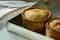 Freshly baked homemade pork pies with golden crust on aluminum baking tray, close up