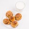Freshly baked homemade snail buns with sugar and cinnamon with milk in glass. Balanced nutrition, proteins and carbohydrates,