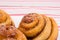 Freshly baked homemade snail buns with sugar and cinnamon on white plate and striped tablecloth. Balanced nutrition, proteins and