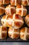 Freshly baked hot cross buns with raisins on a baking tray top view. Traditional Easter pastry. AI generated