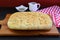 Freshly Baked Italian Herbed Focaccia Bread on Wooden Breadboard