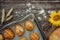 Freshly baked pies, buns on baking sheet and crusty bread, rolling pin, sunflower and ears of wheat on brown wooden background 2