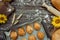 Freshly baked pies, buns on baking sheet and crusty bread, rolling pin, sunflower and ears of wheat on brown wooden background 3