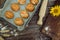 Freshly baked pies, buns on baking sheet and crusty bread, rolling pin, sunflower and ears of wheat on brown wooden background 4