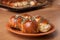 Freshly baked rolls lying in the ceramic dish on wooden table